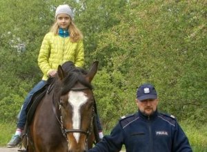 Dziewczynka na koniu i policjant.