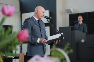 Komendant Miejski Policji w Częstochowie stoi na środku i przemawia do mikrofonu