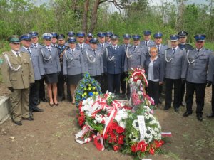 policjanci w mundurach galowych na cmentarzu w Kisielinie stoją w rzędzie podczas Mszy Świętej na cmentarzu - zdjęcie grupowe
