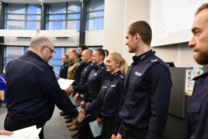 Komendant Wojewódzki Policji w Katowicach gratuluje wyróżnionym policjantom, którzy stoją w szeregu przez podanie ręki i wręczenie dyplomu