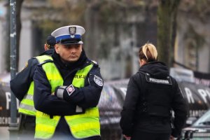 policjant ruchu drogowego Damian Biernacki stoi z założonymi rękami na chodniku