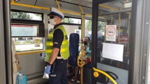 policjant w autobusie przeprowadza kontrolę
