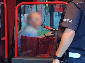 policjant w autobusie przeprowadza kontrolę