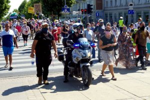 policjant na motocyklu między pielgrzymami przed przejściem dla pieszych