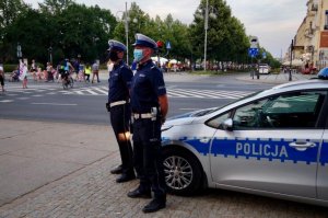 policjanci w odblaskowych kamizelkach stoją przed radiowozem na Placu Sienkiewicza w Częstochowie