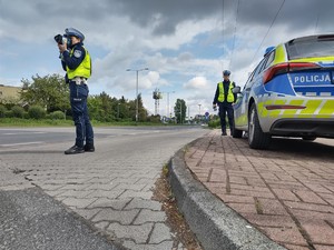 Policyjny patrol stoi przy drodze obok radiowozu